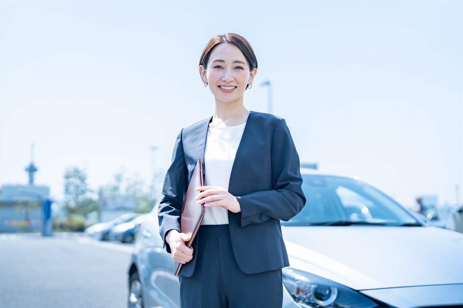 車の前で笑顔で出迎えるスタッフ